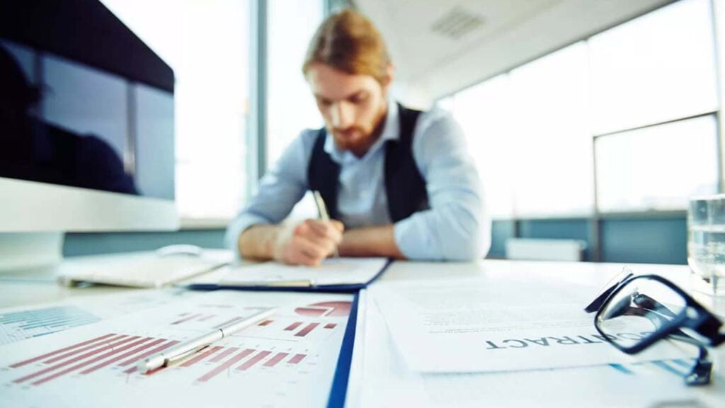 Empresario ejecutivo analizando gráficos y datos en Excel